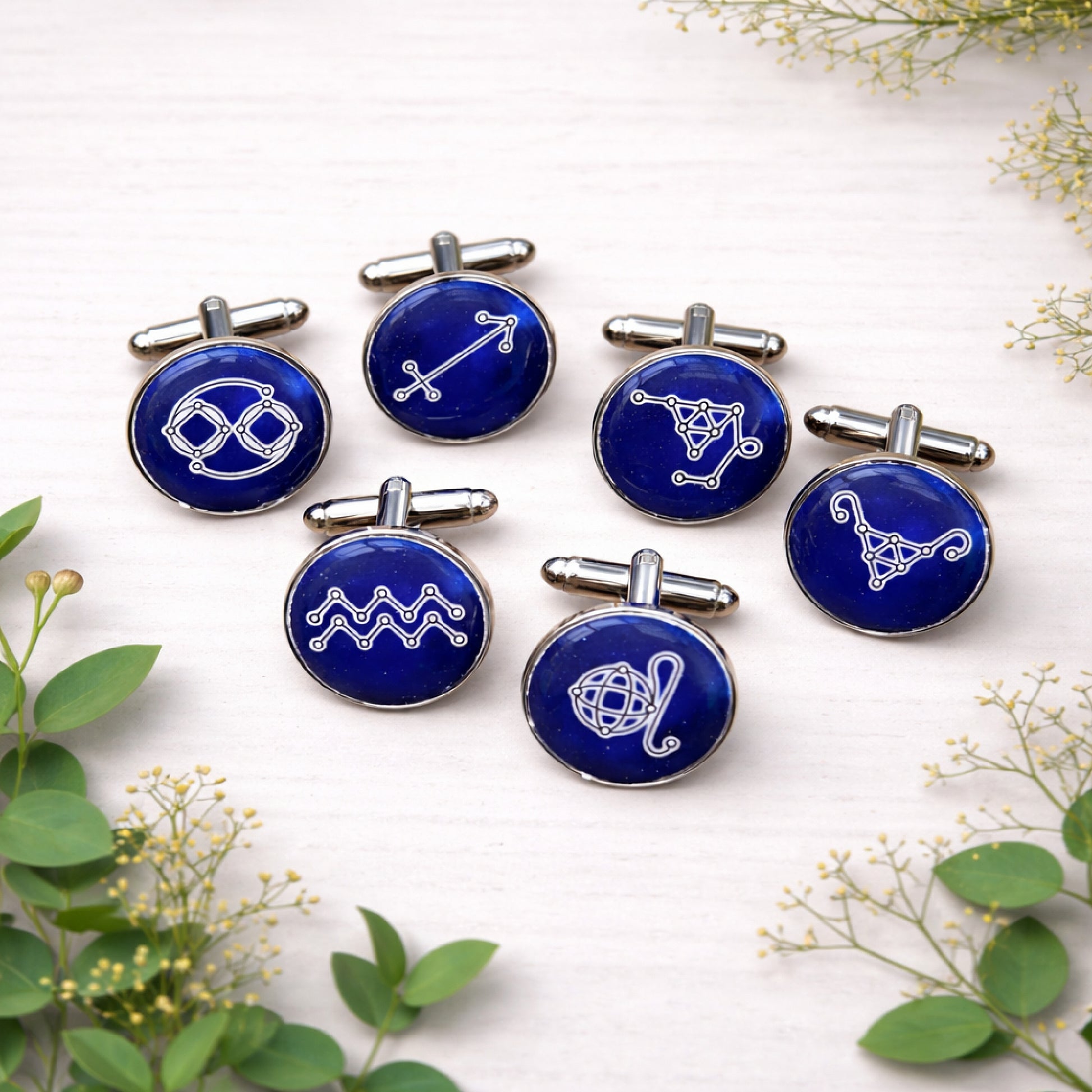 Set of round blue zodiac constellation cufflinks in polished silver finish displayed on a light background.
