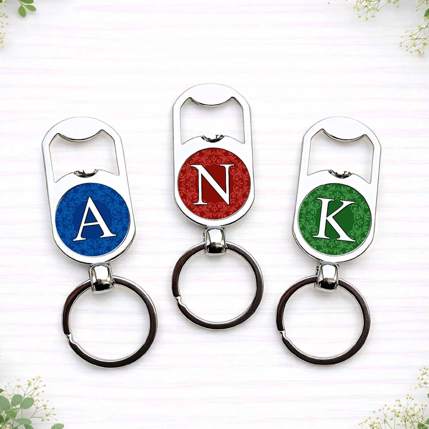 Personalised initial bottle opener keyrings in custom wedding colours featuring monogram letters on circular designs.
