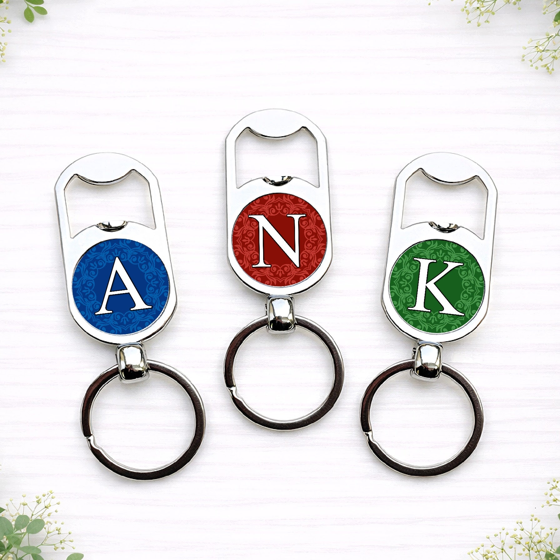 Personalised initial bottle opener keyrings in custom wedding colours featuring monogram letters on circular designs.
