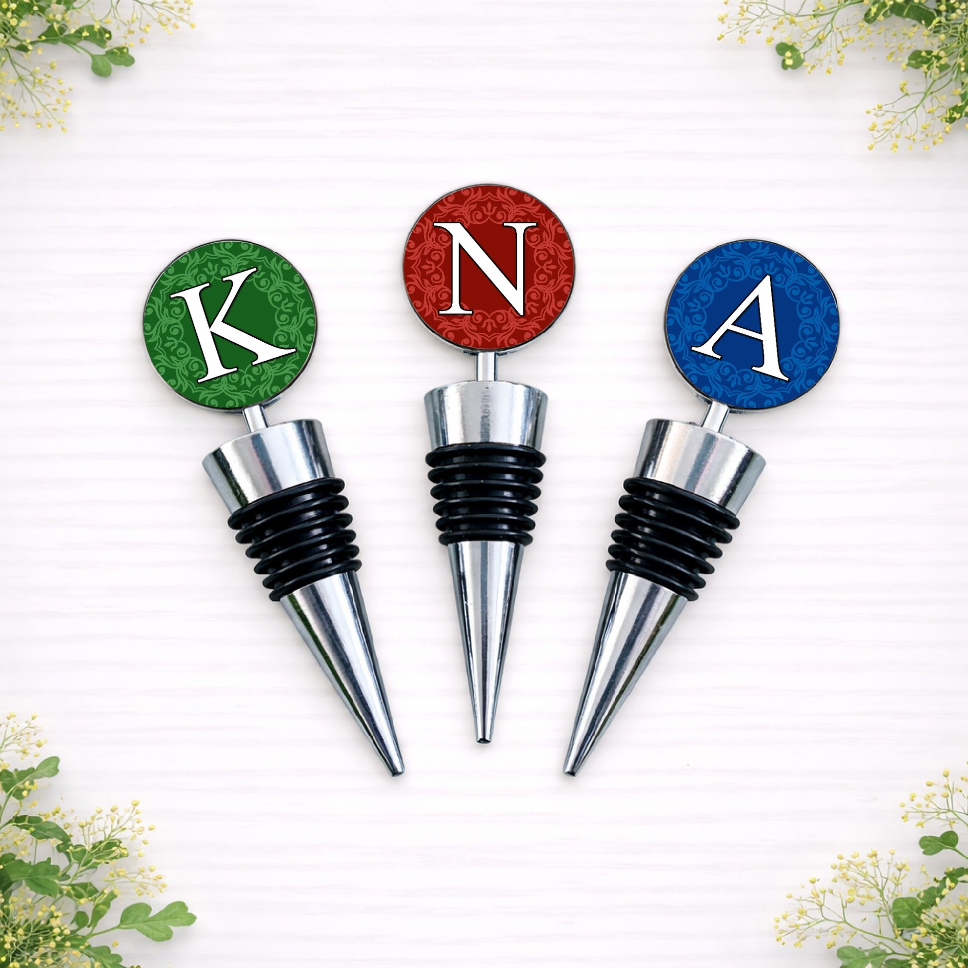 Personalised wedding colour initial bottle stoppers in red, green and blue designs, custom made to match bridal party colours.