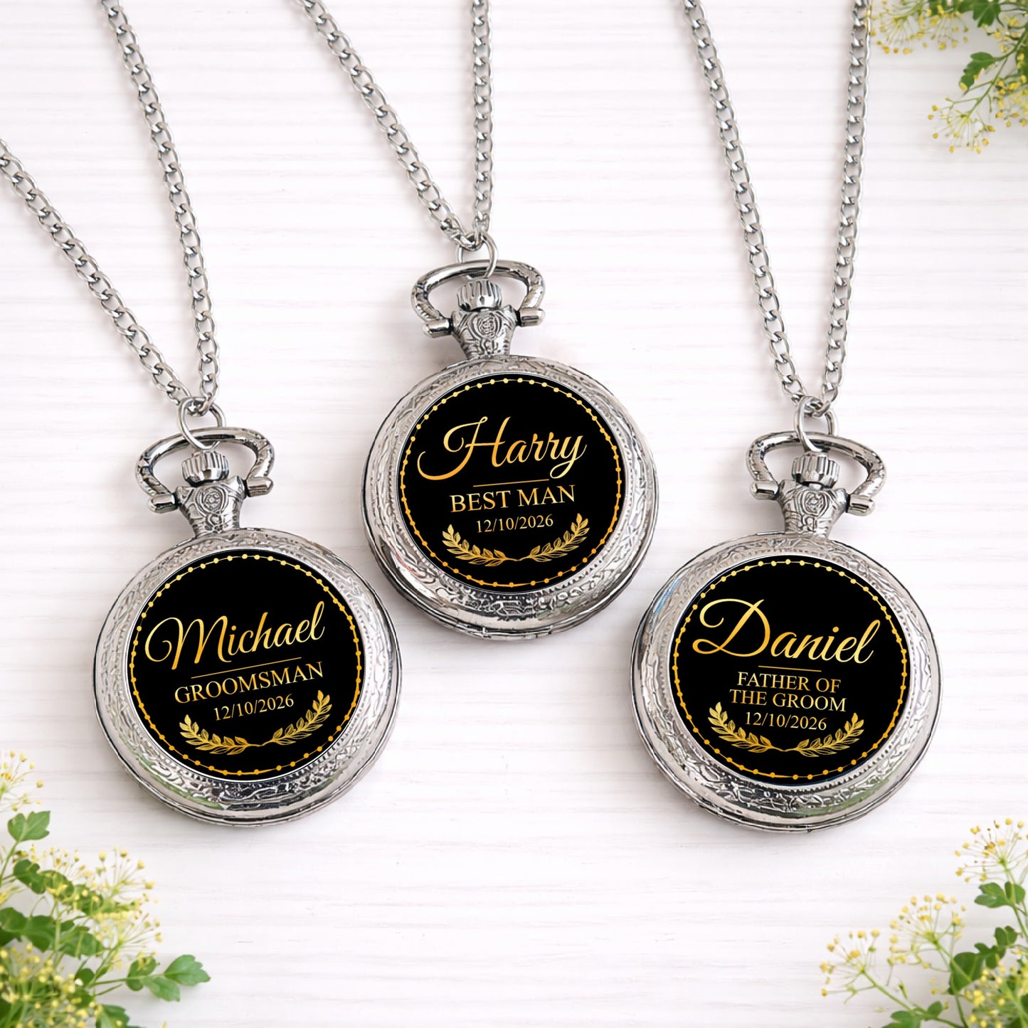 Three personalised black and gold wedding role pocket watches with names and dates displayed on silver chains.