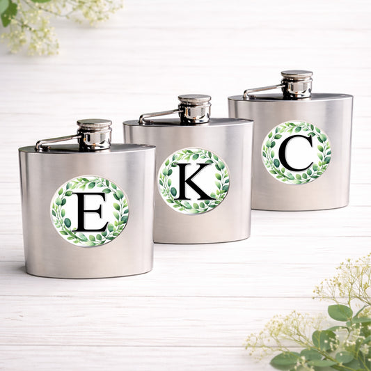 Brushed stainless steel 6oz hip flask personalised with a eucalyptus wreath initial design, custom wedding party gift