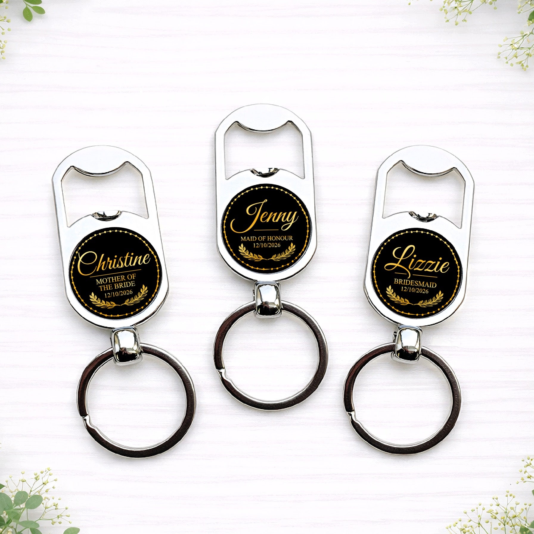 Personalised black and gold bridesmaid bottle opener keyrings with custom names, wedding roles and date in elegant circular seal design.