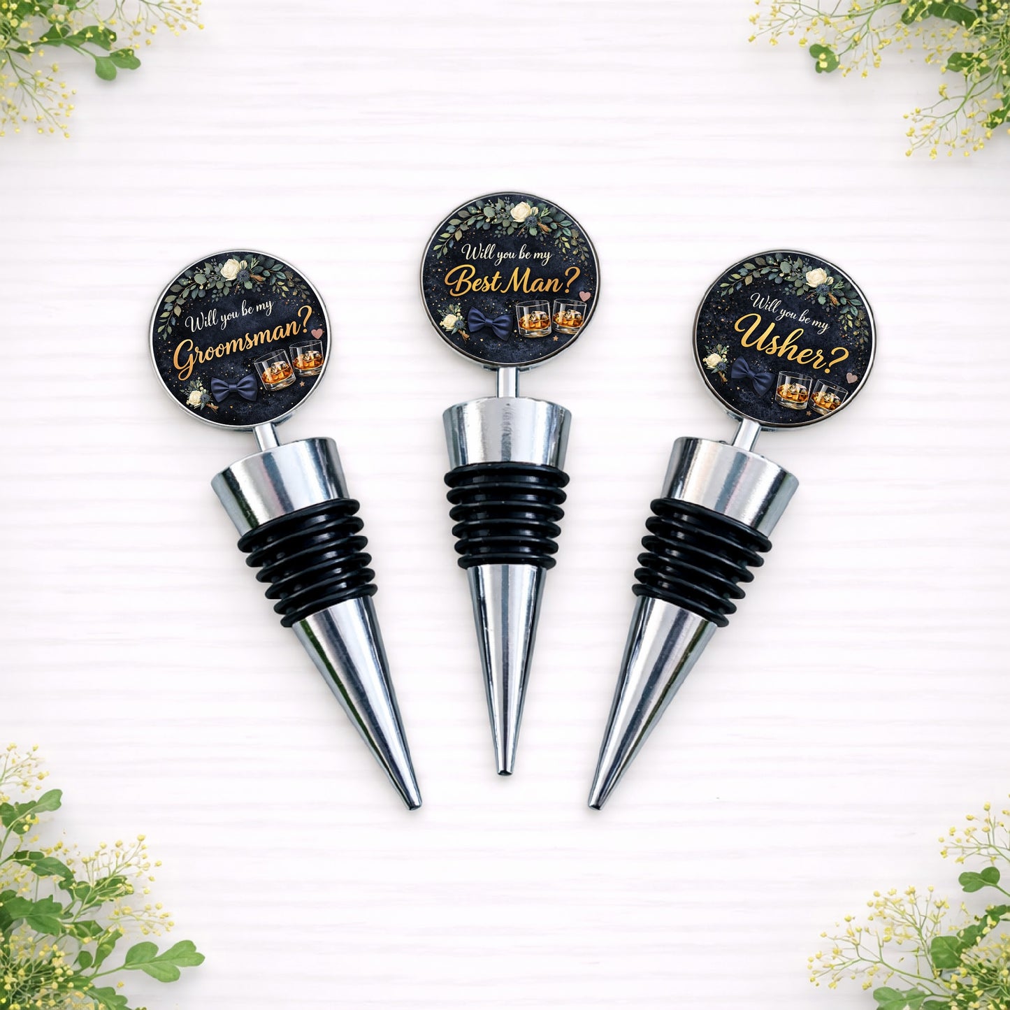 Personalised groomsman proposal bottle stoppers reading “Will you be my Groomsman?”, “Best Man?” and “Usher?” with navy and gold wedding design on silver metal wine stoppers.