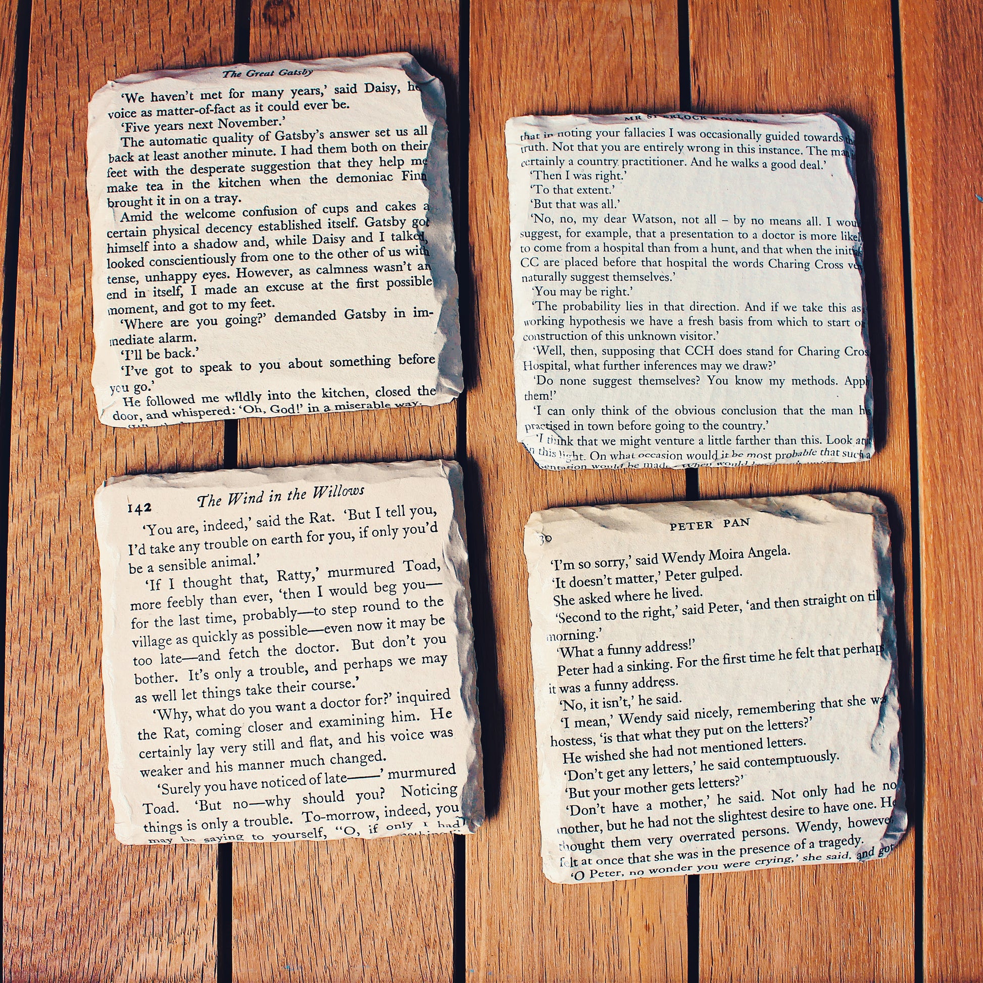 Set of reclaimed vintage book page slate coasters made from classic public domain novels, featuring aged paper mounted onto natural slate bases for a literary wedding theme.